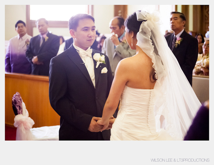 Ceremony holding hands, updo with veil, Triple Twist